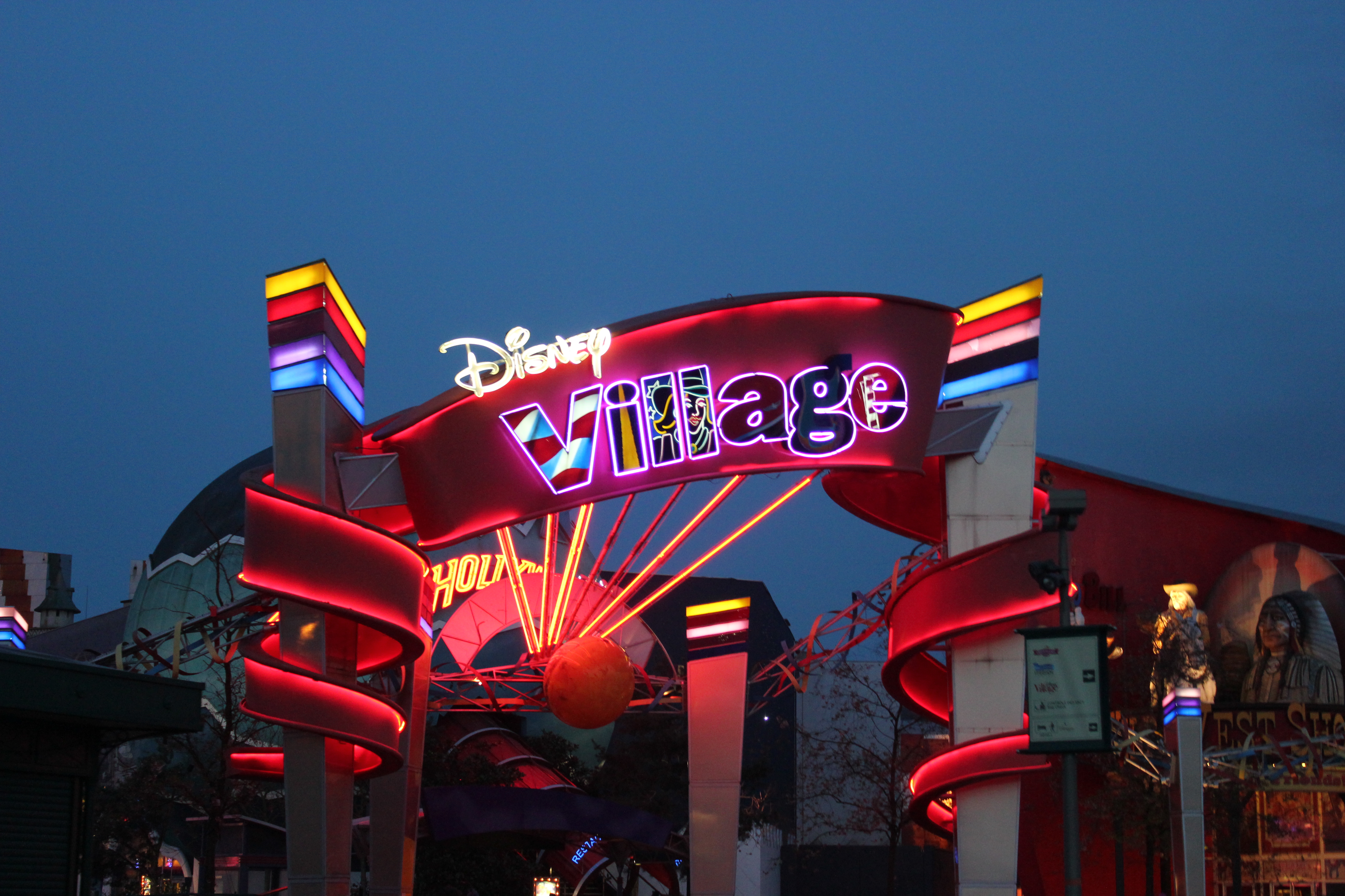 Disney Village sign lit up on a summers night